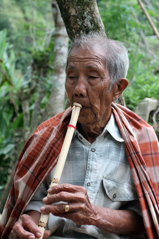 Old man playing flute, Sulawesi